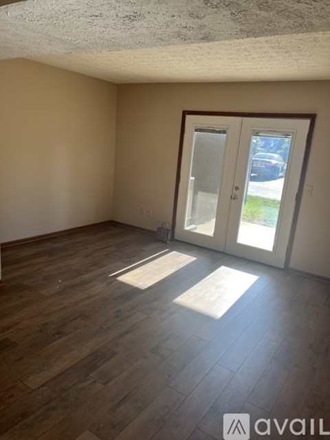 A room with wooden flooring and a sliding glass door.