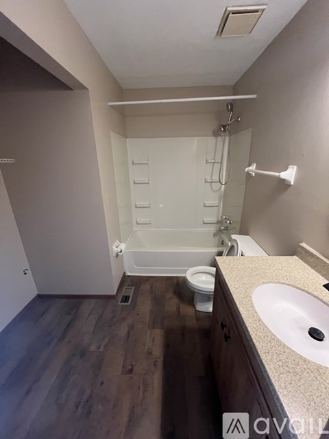 A small, clean bathroom with a toilet, sink, and bathtub.