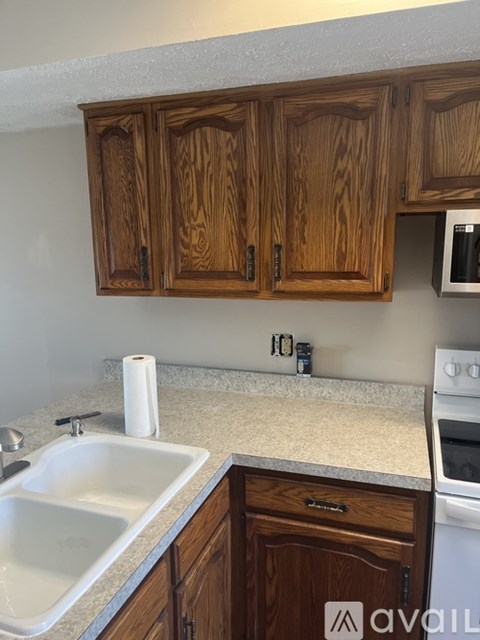 A kitchen with wooden cabinets and a white sink.