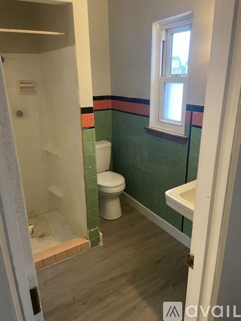 A bathroom with a toilet, sink, and shower.
