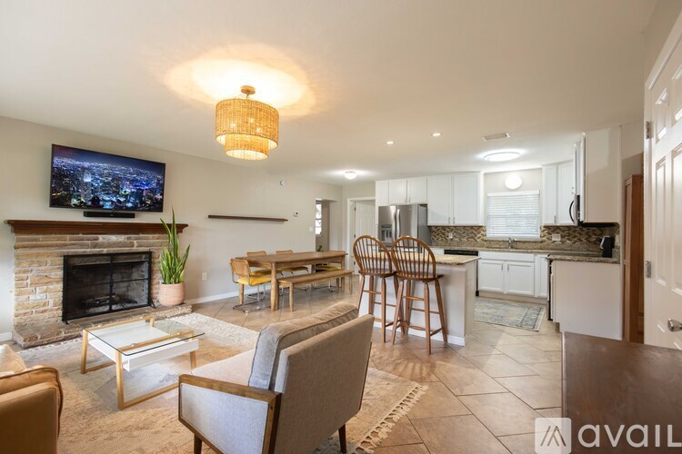 A living room with a fireplace and a television on the wall.