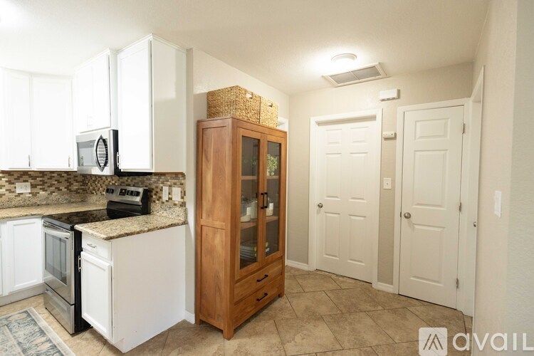 A kitchen with white appliances and a wooden cabinet.