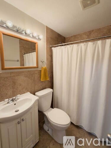 A bathroom with a toilet, sink, and shower.
