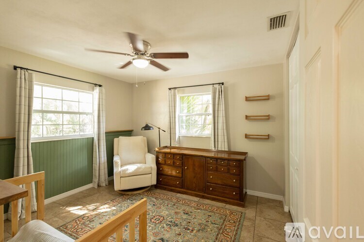 A room with a ceiling fan and a chair.