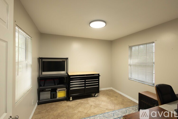 A room with a television, chair, and storage unit.