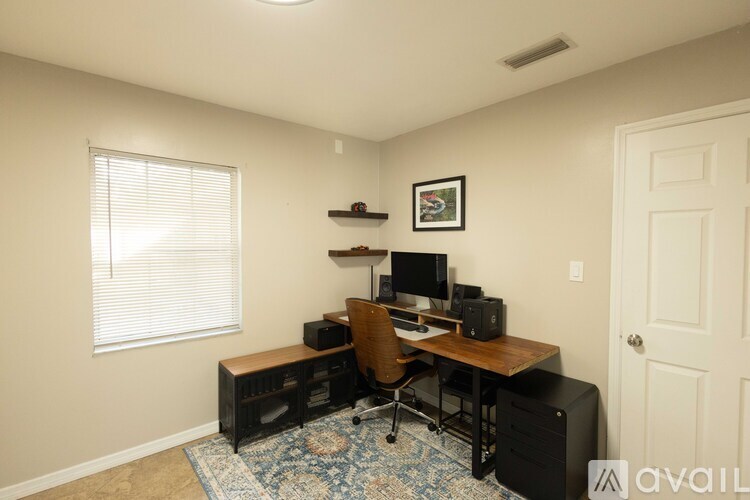 A room with a desk and computer setup.