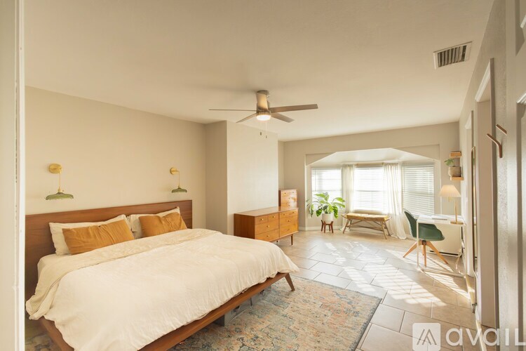 A bedroom with a large bed and a ceiling fan.