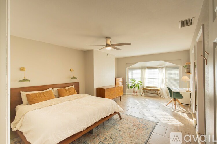 A bedroom with a large bed and a ceiling fan.