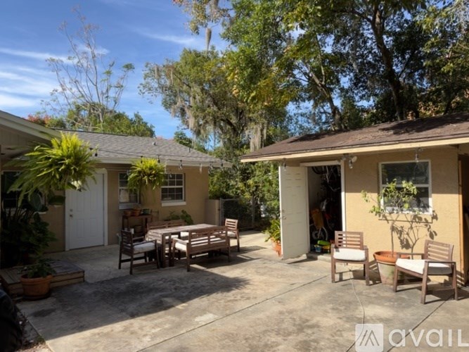 A sunny day at a house with a patio and chairs.