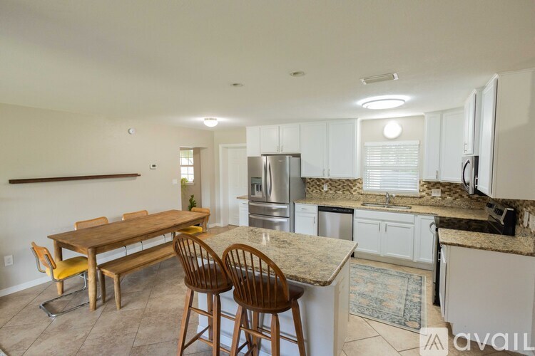 A kitchen with a table and chairs in the middle of the room.