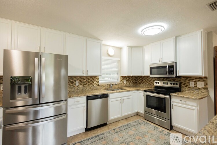 A kitchen with white cabinets and stainless steel appliances.