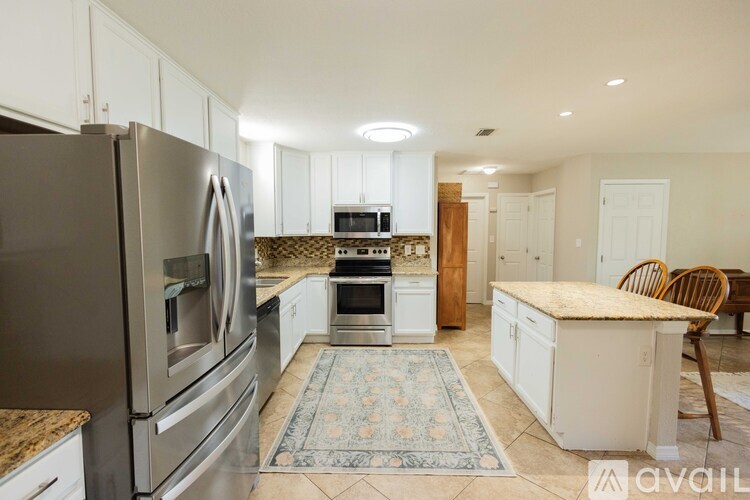 A kitchen with a refrigerator, oven, and sink.