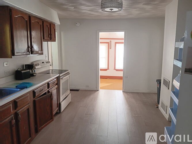 A kitchen with wooden cabinets and a white stove top oven.