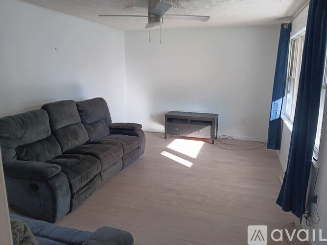 A living room with a black sofa and a small table.