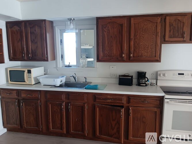 A kitchen with wooden cabinets and white appliances.