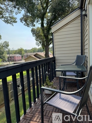 A patio with a table and chairs overlooking a residential area.