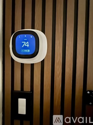 A thermostat on a wall showing 74 degrees.