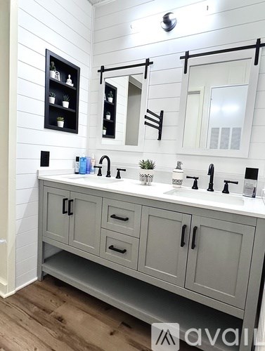 A bathroom with a white sink and grey cabinetry.