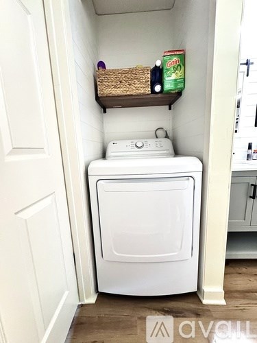 A white washing machine is in a small laundry room.