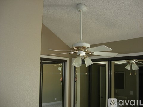 A white ceiling fan with a light fixture hangs from the ceiling in a room.
