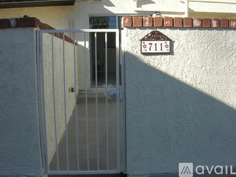 A gate with a sign that says 7111 on the wall behind it.