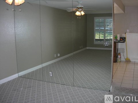 A room with a ceiling fan and a window with blinds.
