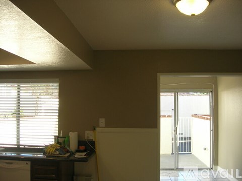 A room with a desk and a window with blinds.