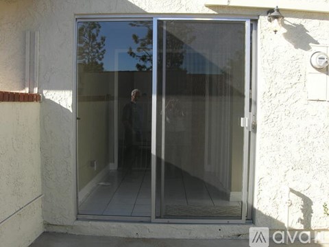 A person is standing inside a glass door.