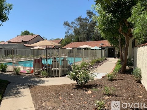 A pool surrounded by a fence and trees.