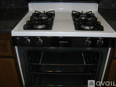 A white stove top with two burners and a black oven with a glass door.