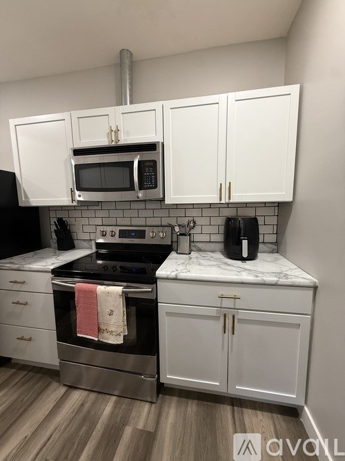 A kitchen with white cabinets and a black stove top oven.