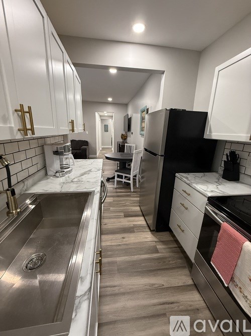 A kitchen with a marble countertop and stainless steel appliances.