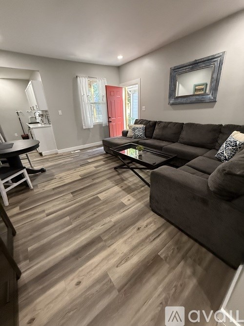 A living room with a grey couch and a wooden floor.