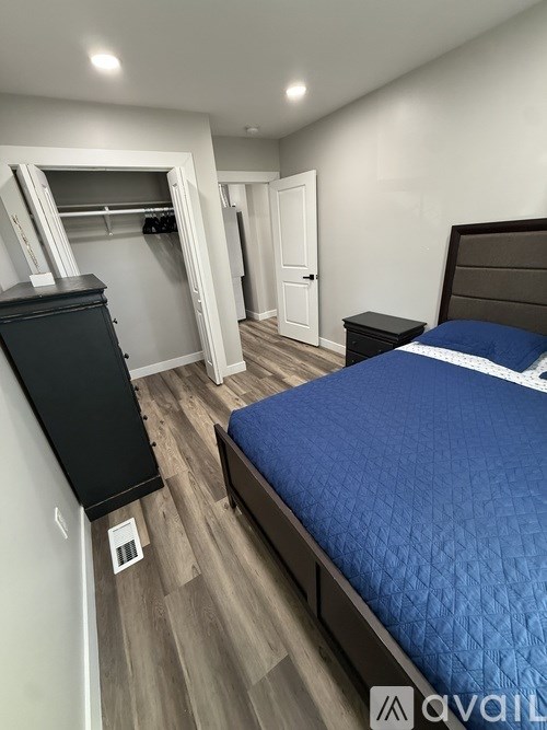 A bedroom with a blue bedspread and a black headboard.