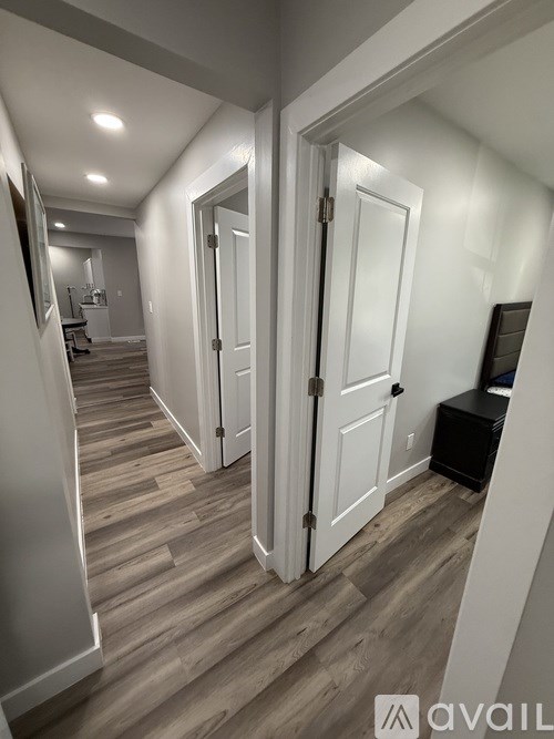 A hallway with a white door and a bench.