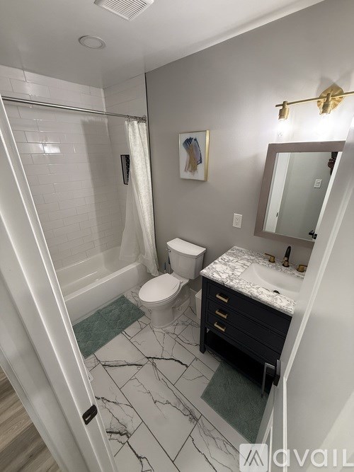 A bathroom with a marble floor and a toilet.
