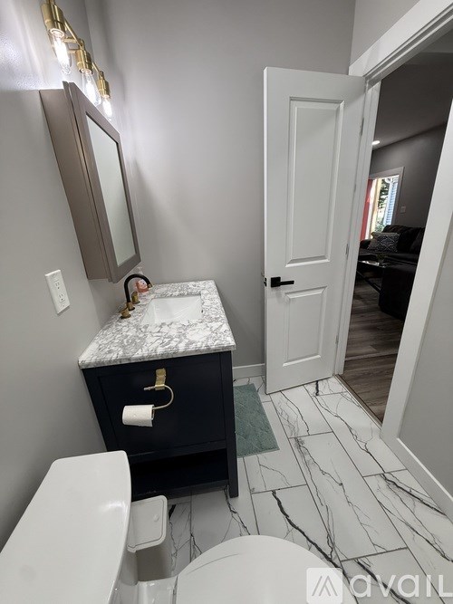 A bathroom with a marble countertop and a white toilet.