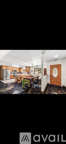 A room with a wooden door and a green chair.
