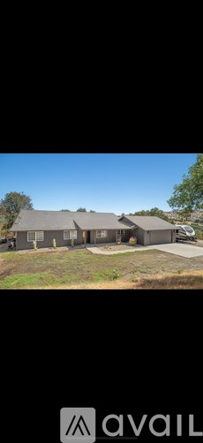 A house with a grey roof and a car parked in front.