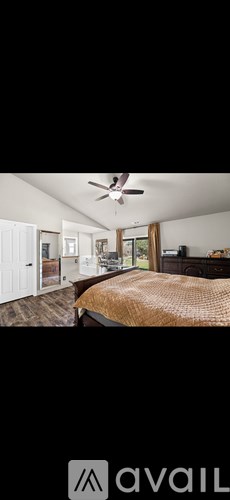 A bedroom with a bed and a ceiling fan.
