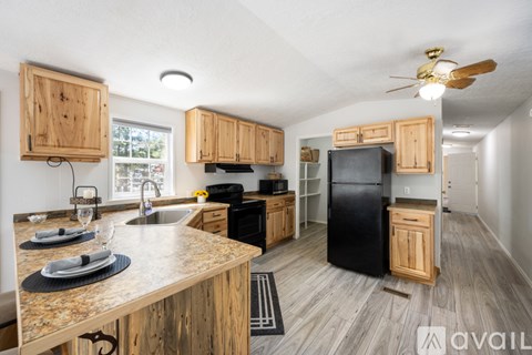 A kitchen with wooden cabinets and a black refrigerator.