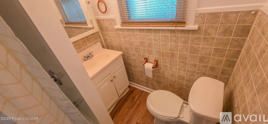 A small white toilet sits in a small bathroom.