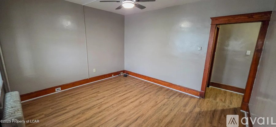 A room with wooden floors and a ceiling fan.