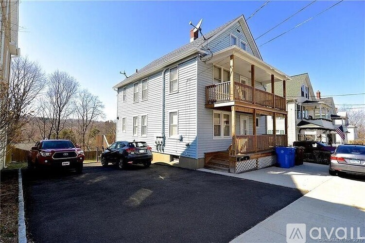 A two-story house with a garage and a car parked in front.