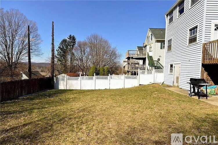 A backyard with a white fence and a bench.