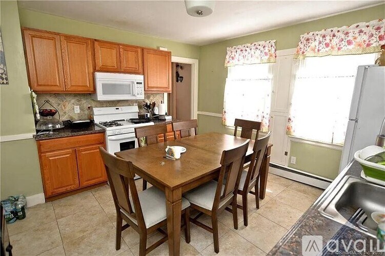A kitchen with a table and chairs in front of a window.