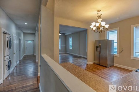 A spacious laundry room with a chandelier and a washer and dryer.
