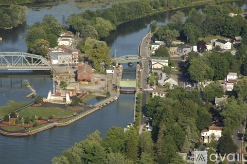 A river flows through a town with a bridge crossing over it.
