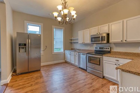 A kitchen with a refrigerator, oven, and microwave.