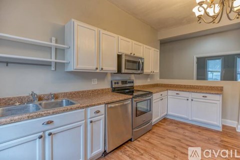 A kitchen with white cabinets and stainless steel appliances.